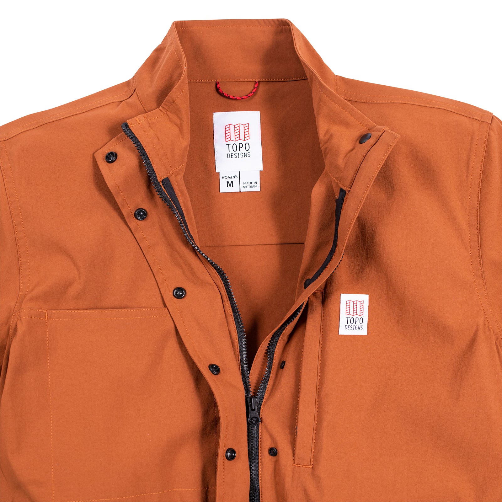 General detail shot of the Topo Designs Women's Coverall in Brick showing collar, front zipper, and snaps open.