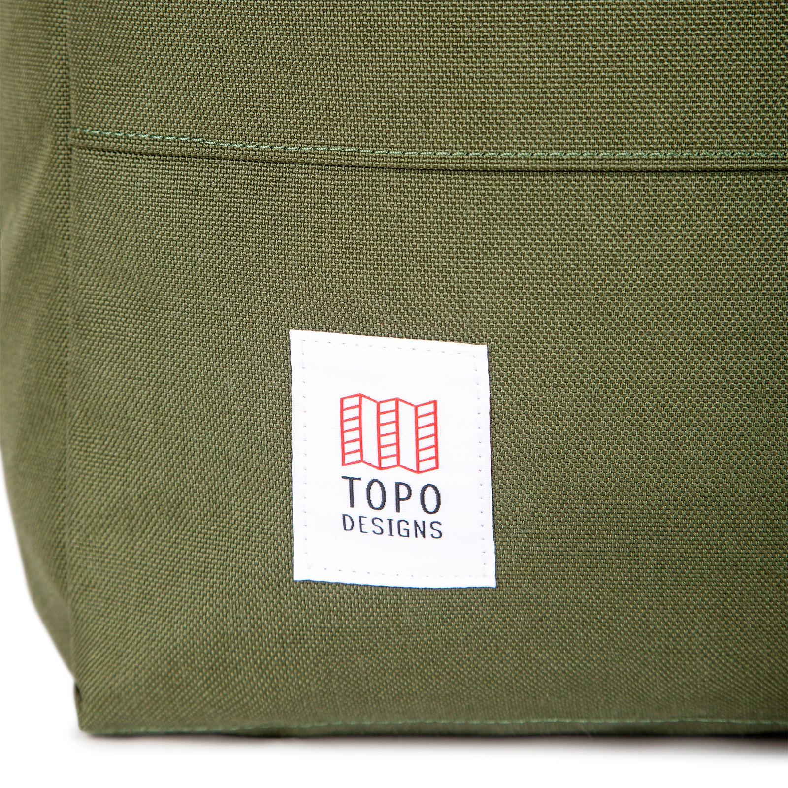 General shot of front logo patch on Topo Designs Daypack Classic 100% recycled nylon laptop backpack for work or school in Olive green.