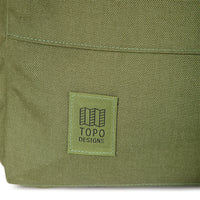 General shot of logo patch on Topo Designs Daypack Tech 100% recycled nylon backpack in "Olive" green.