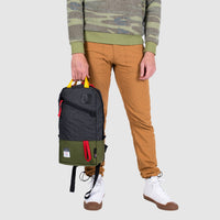 Model shot of Topo Designs x Alternative Trip Pack in olive/black showing top carry handles