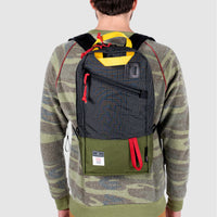 Back model shot of Topo Designs x Alternative Trip Pack in olive/black showing backpack size