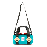 General front detail shot of Topo Designs Mini Classic Duffel Bag in Turquoise blue showing shoulder strap.