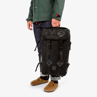 General shot of Topo Designs Klettersack Heritage Canvas backpack in Black Canvas / Black Leather held by model.