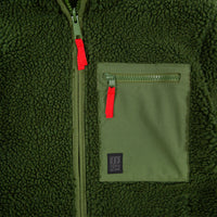General detail shot of Topo Designs Men's Sherpa Jacket in Olive green showing sherpa fleece side, zipper, and chest zipper pocket with logo patch..