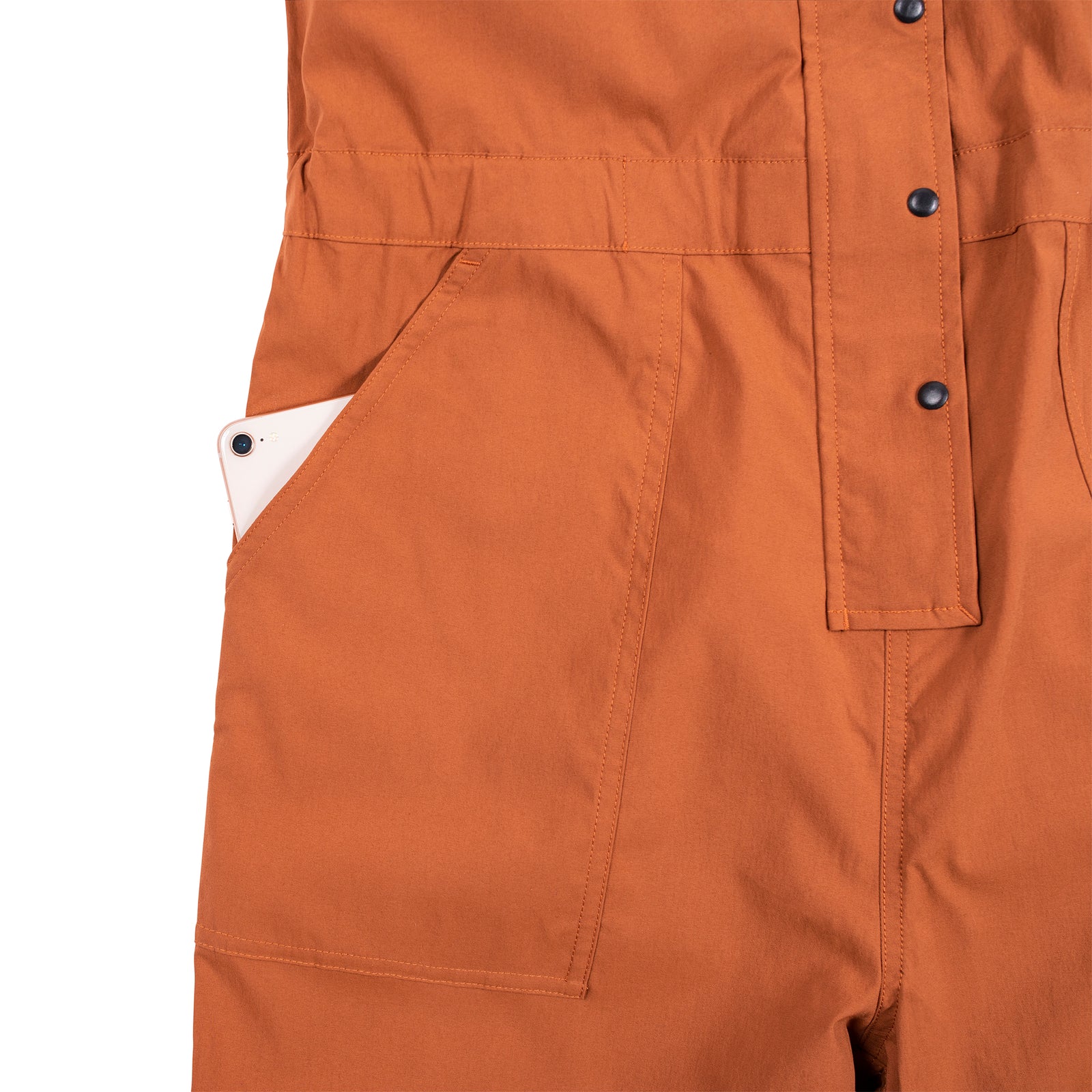 General detail shot of the Topo Designs Women's Coverall in Brick showing front hand pockets.