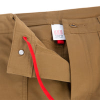 General shot of Topo Designs Men's Global Pants lightweight cotton nylon travel pants in Dark Khaki brown showing red internal drawstring