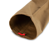 General shot of Topo Designs Men's Global Pants lightweight cotton nylon travel pants in Dark Khaki brown showing leg opening and cinch cord.