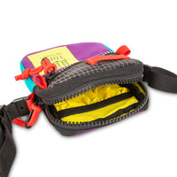 General shot of yellow lining inside of Topo Designs Mini Shoulder Bag crossbody travel purse in Purple Black Ripstop detail showing zipper opening and interior pocket.