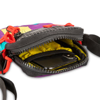 General shot of yellow lining inside of Topo Designs Mini Shoulder Bag crossbody travel purse in Purple Black Ripstop detail showing zipper opening and interior pocket with phone.
