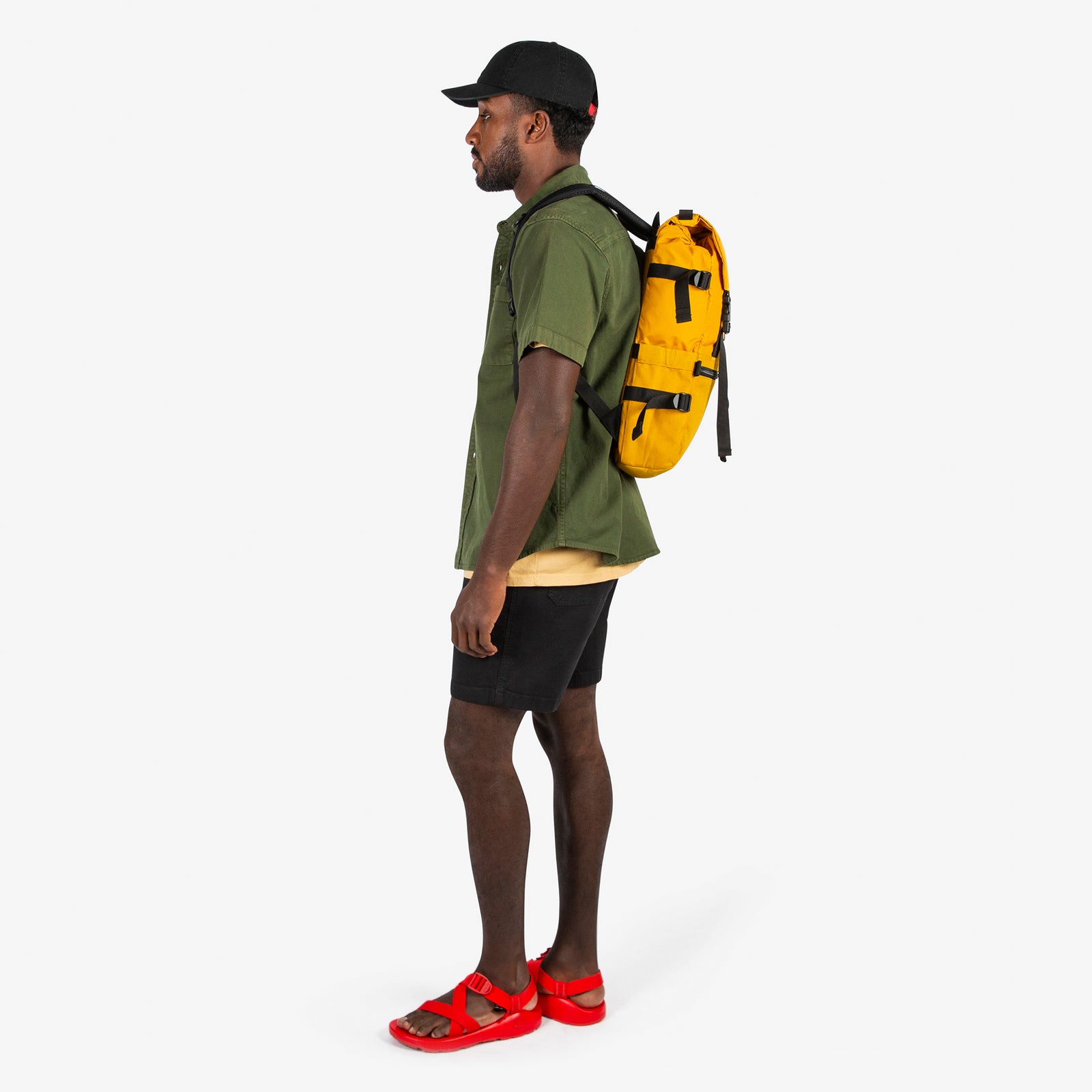 Topo Designs Rover Pack Classic in "Mustard" yellow carried by model with backpack straps.