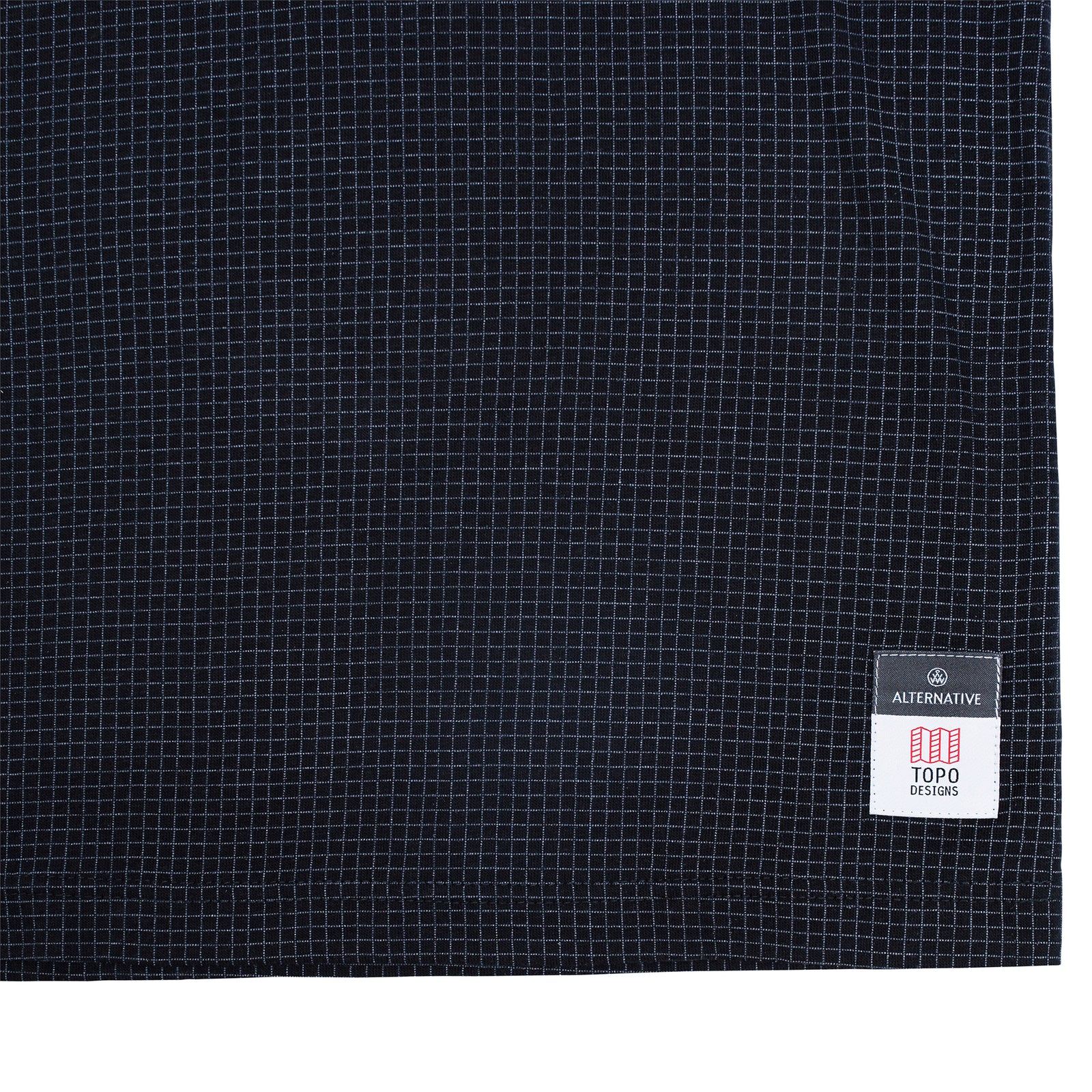 Detail shot of Topo Designs x Alternative Eco-Jersey Crew Tee in true black grid showing tag along bottom hem.